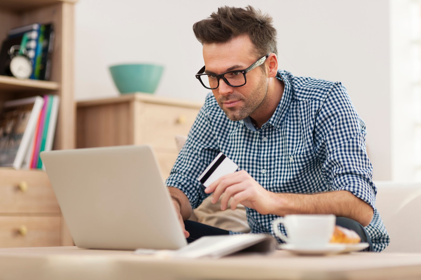 Hombre usando una computadora para hacer una compra en línea.