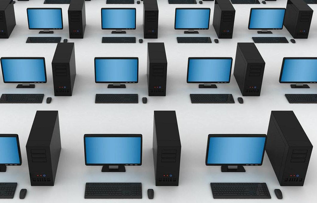 Múltiples computadoras acomodadas en filas y columnas sobre una superficie.