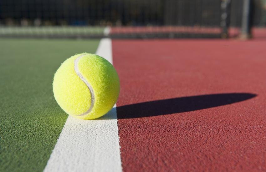 Pelota de tenis en el límite de una cancha.