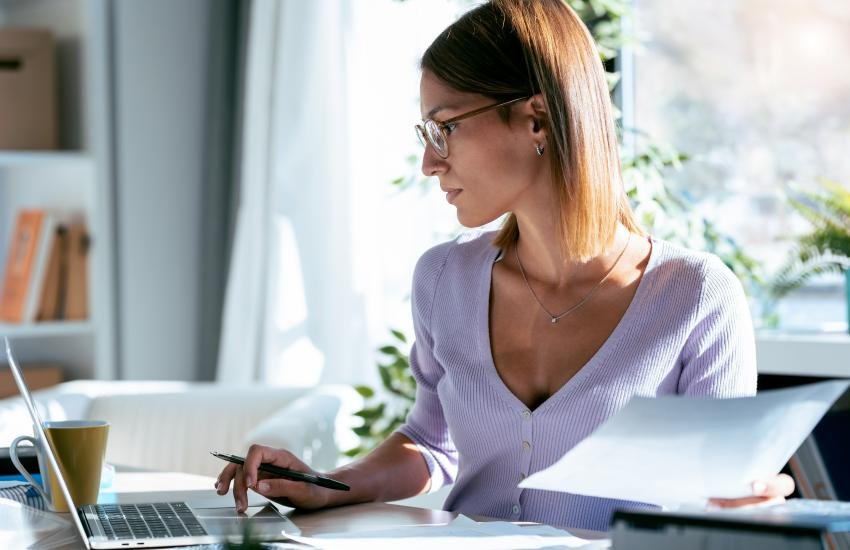 Mujer con computadora trabajando desde casa.